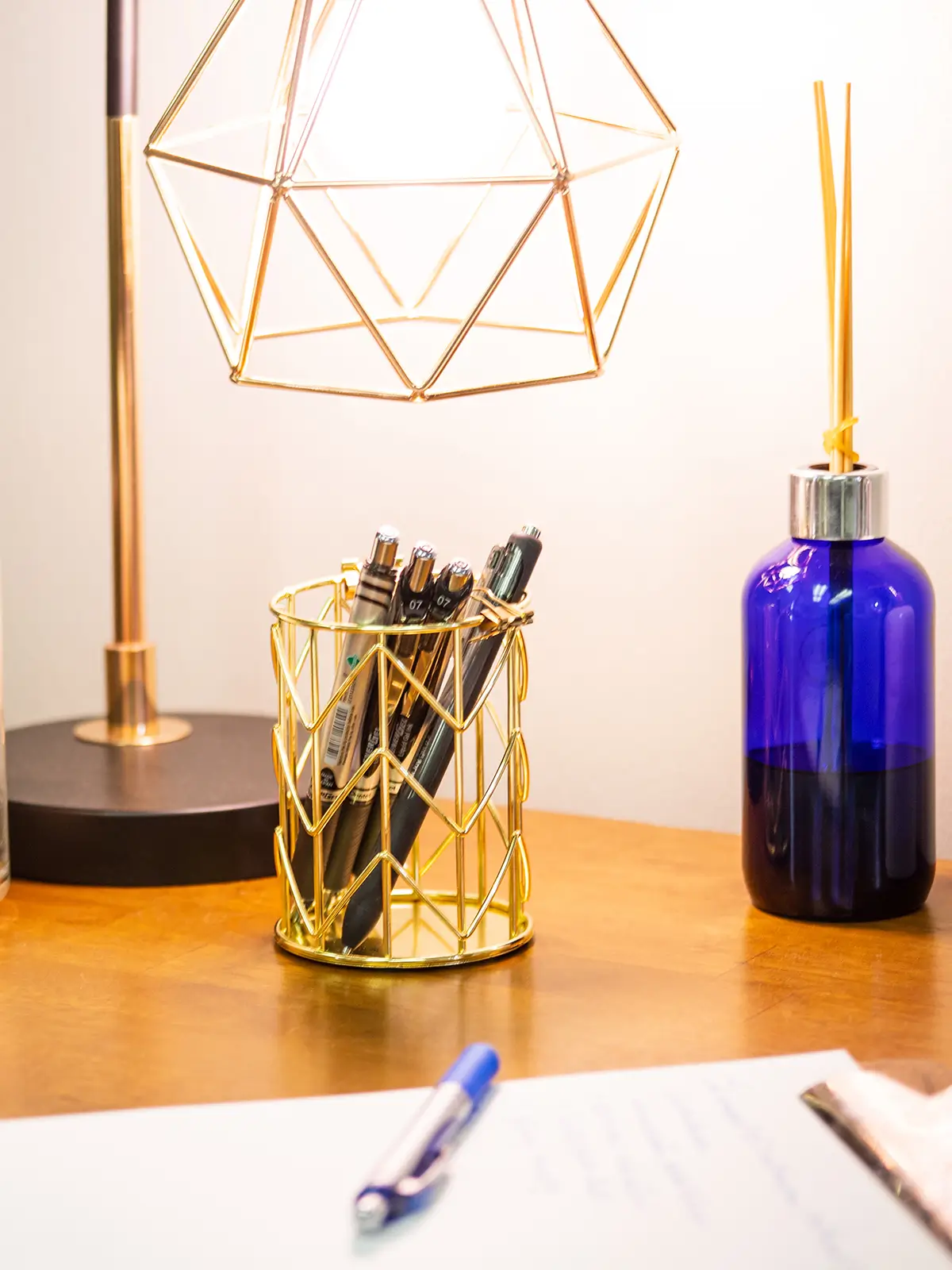 desk-min note pad, lamp, pens, and other items on a desk.