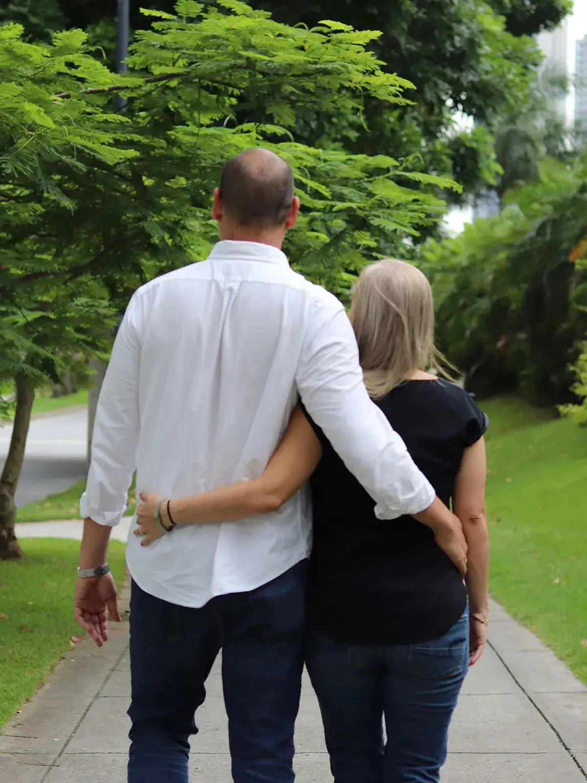 find-clarity A couple with their arms around one another as they walk on a sidewalk