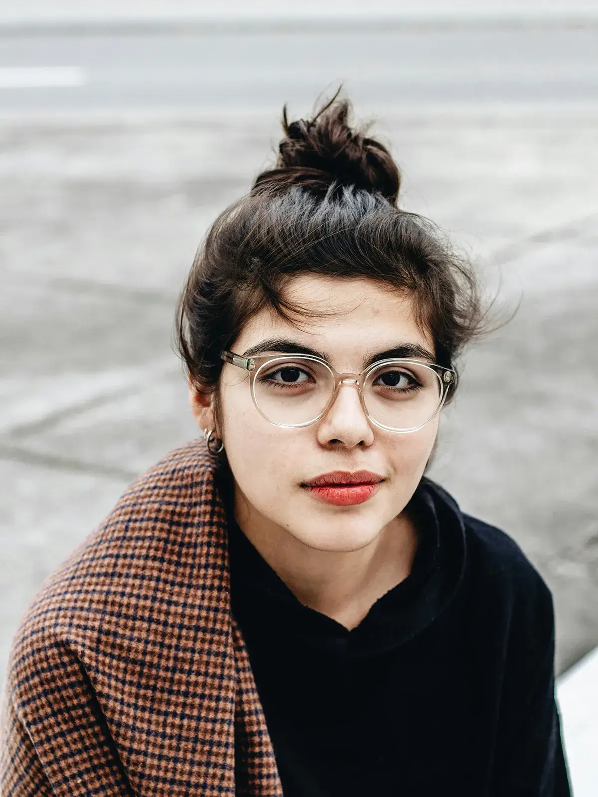 get-relief-from-OCD A woman wearing glasses with her hair in a bun