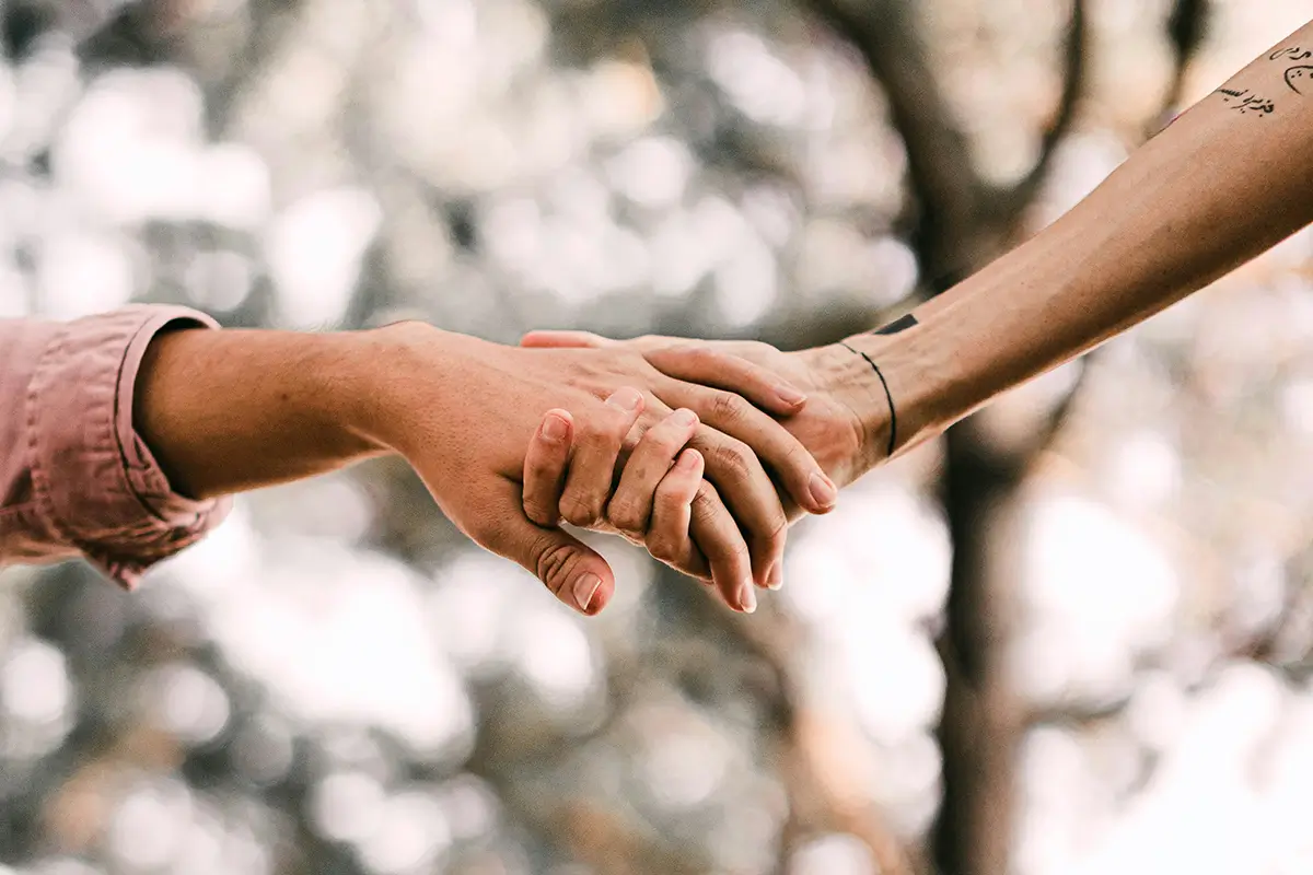 Two adults holding hands as a sign of support