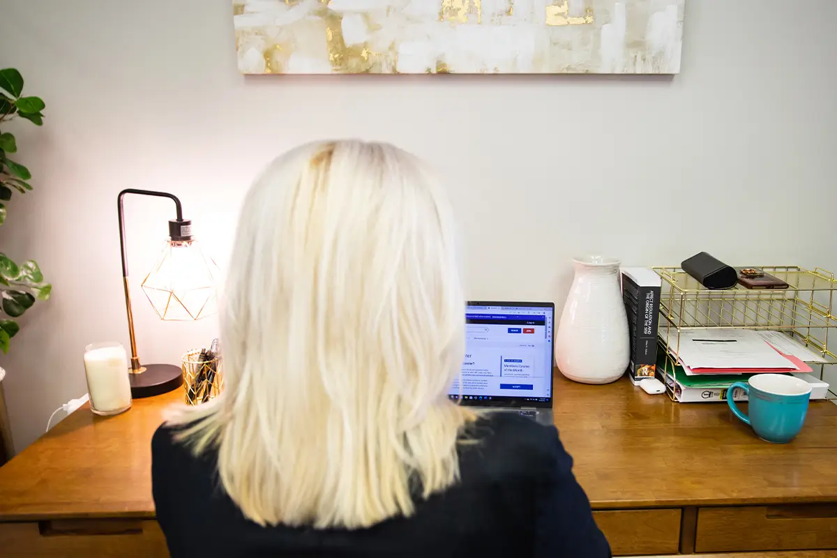 What Type of Doctor Treats Anxiety Disorders? Woman working on a laptop at a desk in a home office.